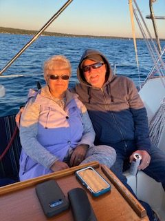 Couple on sunset sail on 2nd Wind sailboat on grand traverse bay in Traverse City, Michigan with WIND Sailing.