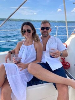 couple in white clothes on sailboat