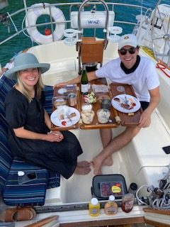 Couple enjoying lunch on 2nd Wind sailboat on grand traverse bay in Traverse City, Michigan with WIND Sailing.